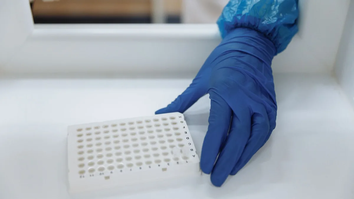 Scientist with protective gloves handling test samples in a sterile laboratory environment. — Illustration for a report on the cagrilintide retatrutide combination study in obese rats published in Nature Metabolism
