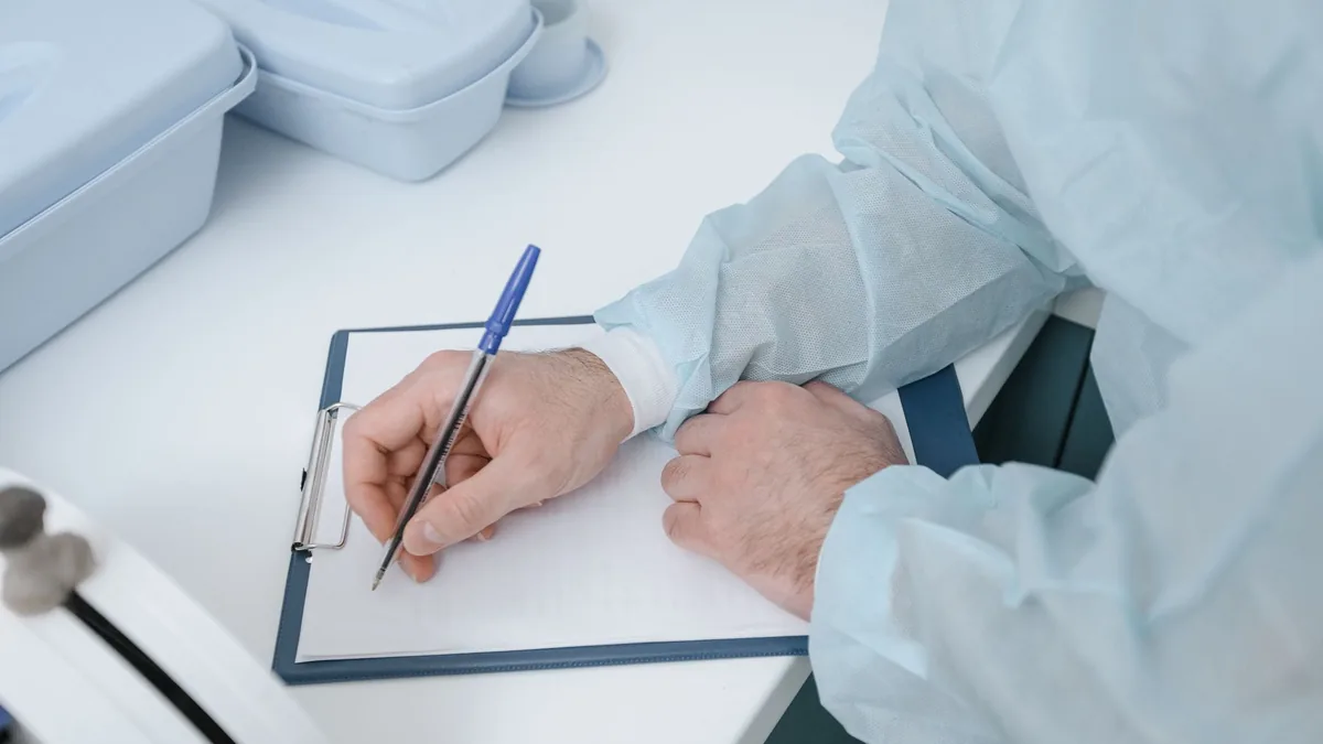 A medical professional wearing protective clothing writing on a clipboard. — Illustration accompanying a report on GLP-1 after bariatric surgery and the Phase 4 randomized trial now recruiting patients