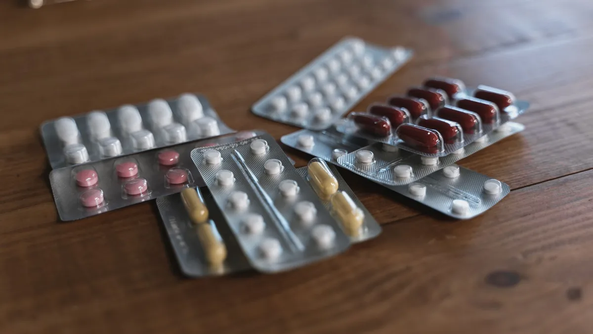 Heaps of various medication pills of different color and shape in blister packs placed on bright yellow background — Illustration accompanying coverage of the new Phase 3 oral semaglutide weight loss trial registration