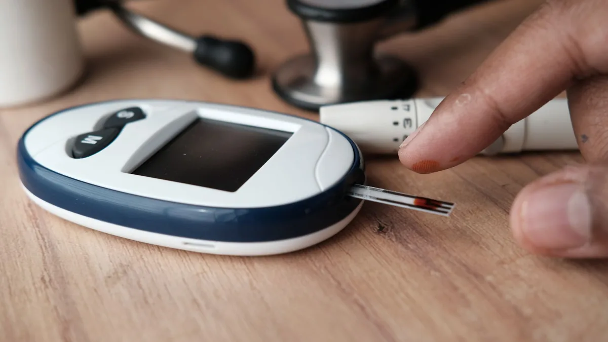 A close-up of a finger prick and blood glucose monitor for diabetes testing. — Illustration accompanying a report on retatrutide diabetic ketoacidosis in a patient with type 1 diabetes