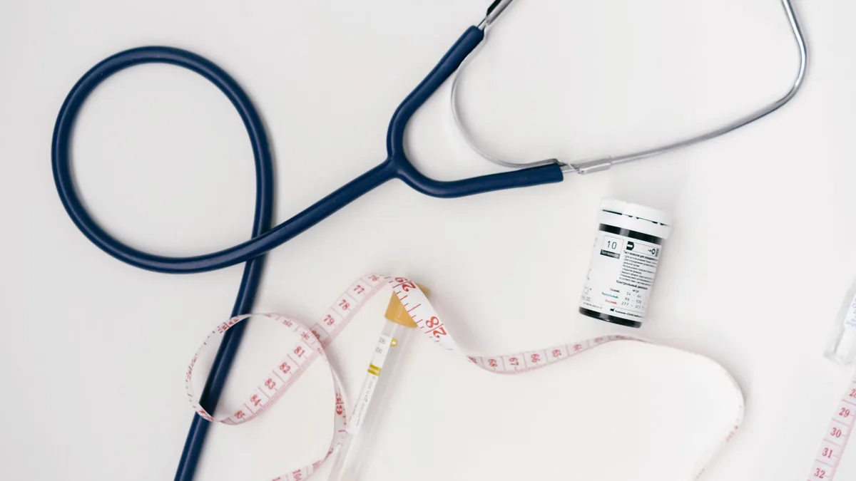Flat lay of medical tools including stethoscope and measuring tape on a white background. — Illustration accompanying coverage of a semaglutide muscle loss study and new GLP-1 lean mass trials