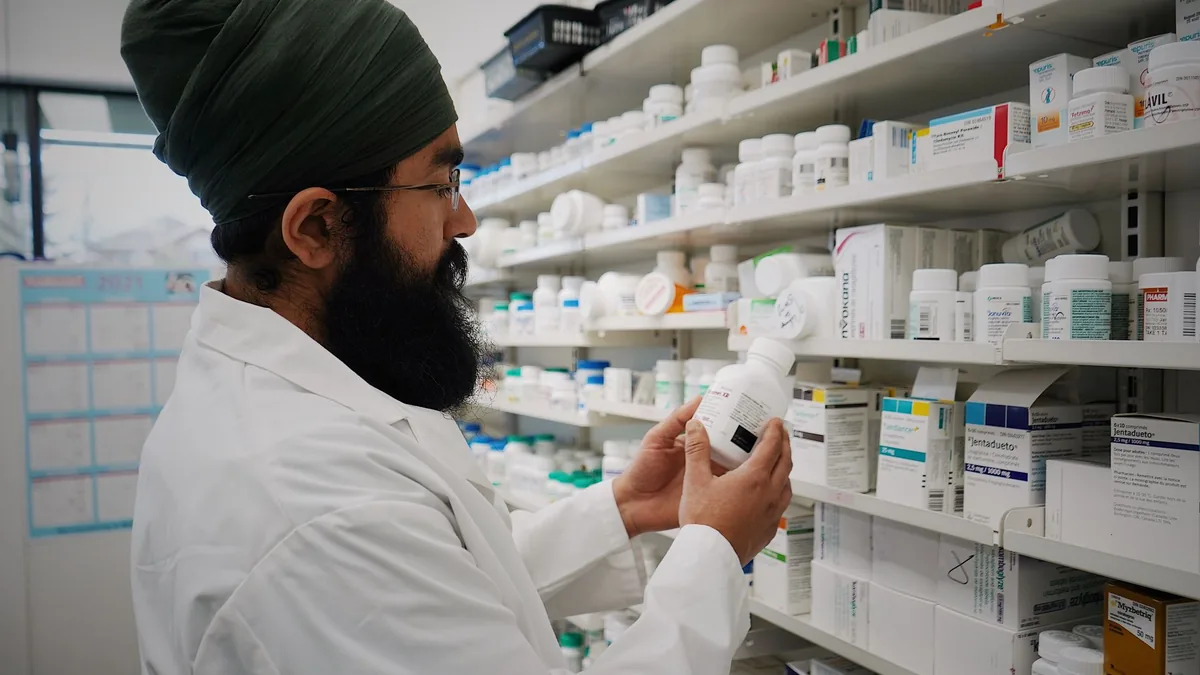 Pharmacist with turban organizing shelves in a pharmacy, focused on healthcare. — FDA announcement that the tirzepatide shortage is resolved and compounder policies clarified