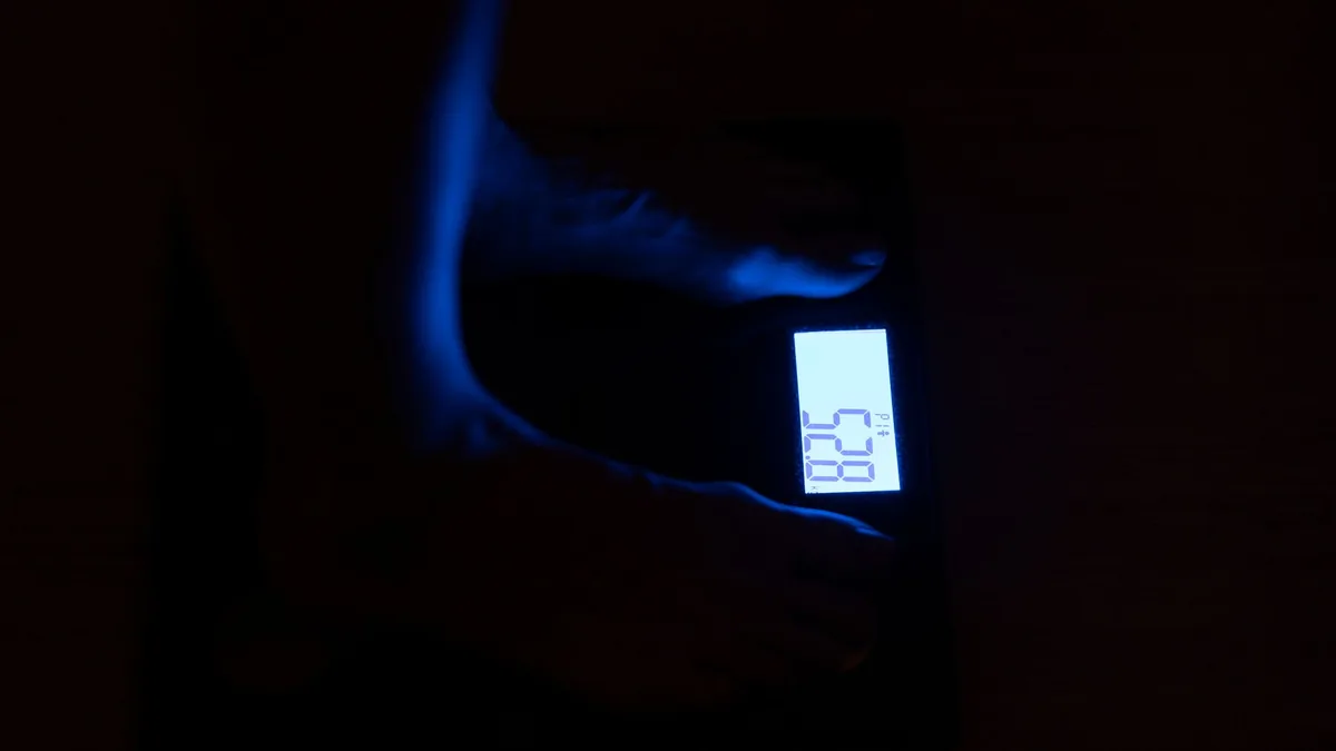 Close-up of a digital weighing scale displaying weight in a dark room with blue illumination. — Illustration accompanying coverage of new research on weight regain after stopping semaglutide and tirzepatide